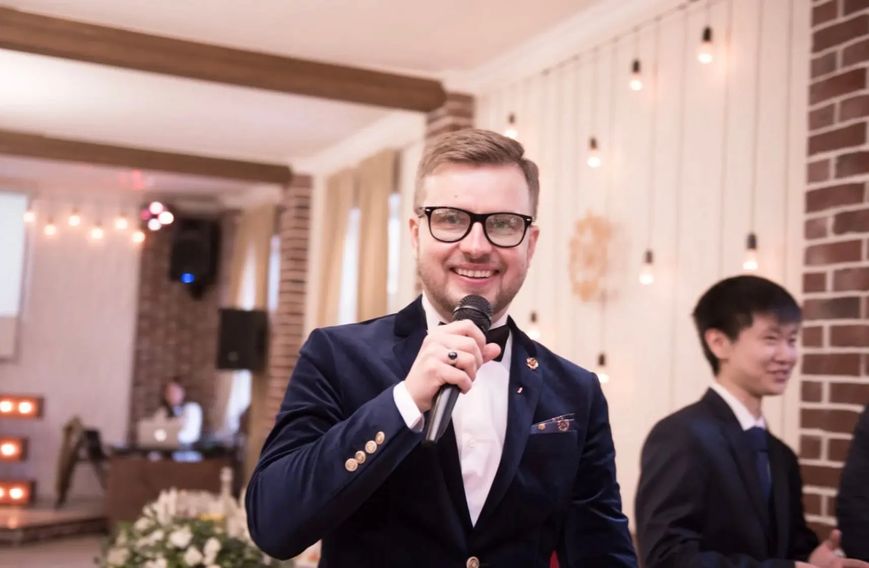 Ведущий в синем костюме с микрофоном